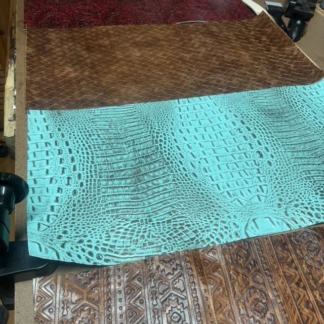 A panel of turquoise-dyed leather embossed with a scaled texture