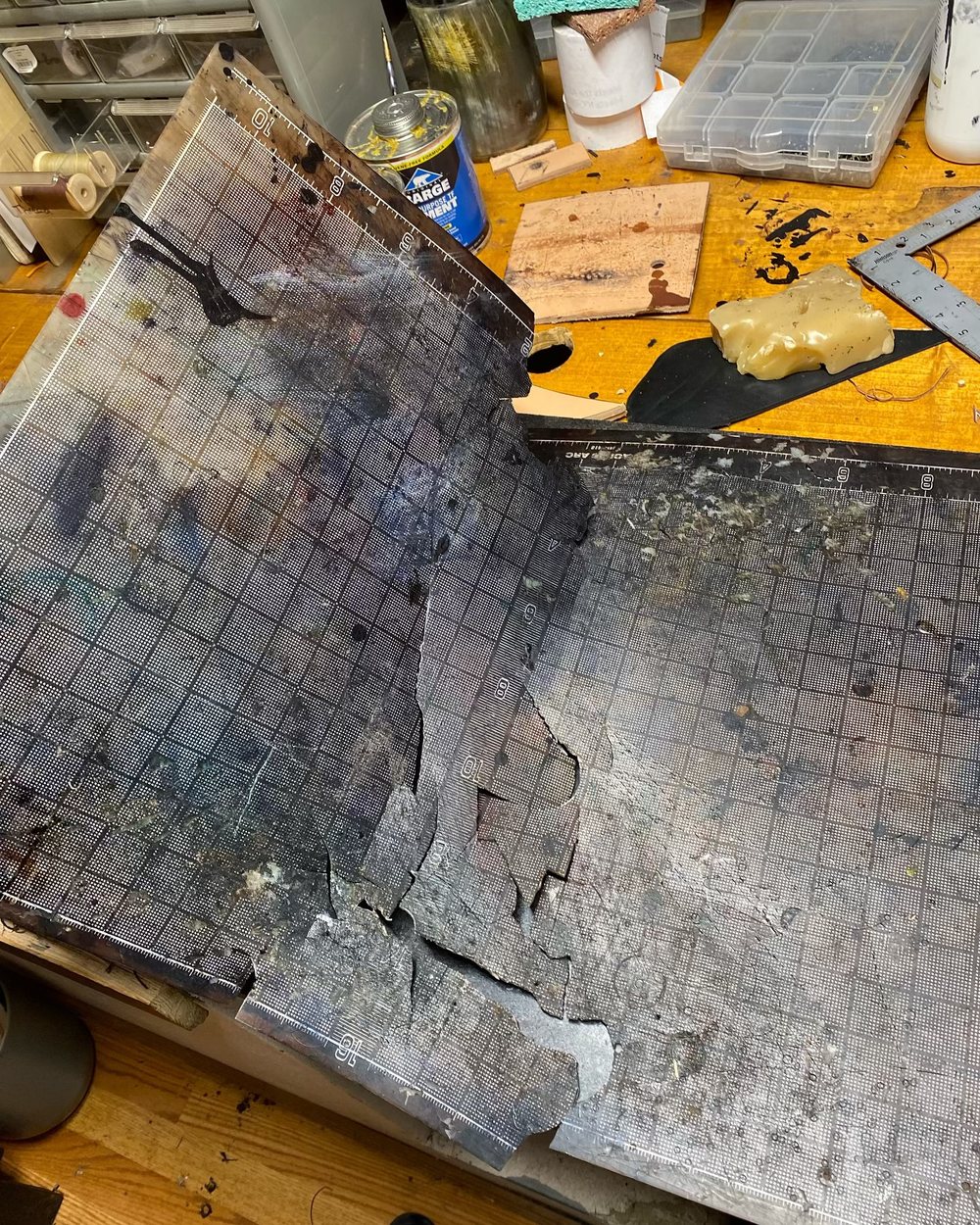 The cutting bench and its board, scarred and darkened by use