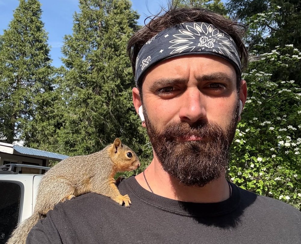 The maker outdoors in a bandana, a ground squirrel perched on his shoulder